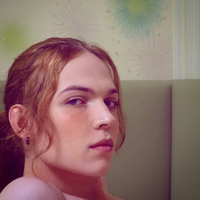 Close-up of Liz with long auburn hair, looking into the camera