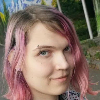 Photo of Liz: pink hair, choker, a little smile